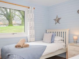 A bedroom with a bed and window at Cornish Woodland Retreat Near St Tudy
