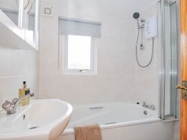 A bathroom with a bathtub and a shower at Cornish Woodland Retreat near St Tudy