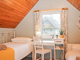 A bedroom with a bed, desk, and window at Cornish Woodland Retreat Near St Tudy