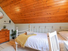 A bedroom with a bed and dresser at Cornish Woodland Retreat Near St Tudy