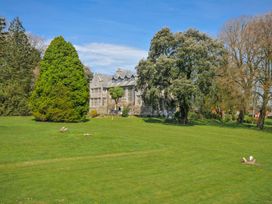 An outdoor area with a building and trees at Cornish Woodland Retreat Near St Tudy