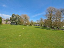 An outdoor area with a grass field and trees at Cornish Woodland Retreat near St Tudy
