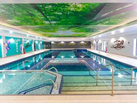 An indoor swimming pool with a ceiling mural at Cornish Woodland Retreat Near St Tudy