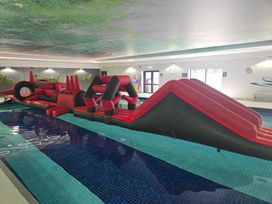 An inflatable obstacle course in an indoor pool at Cornish Woodland Retreat Near St Tudy