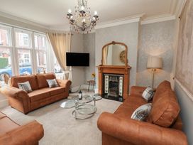 A living room with a sofa and TV at 11 Rutland Street in Filey