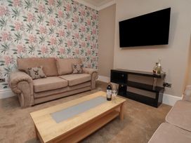 A living room with a sofa and a television at 11 Rutland Street in Filey