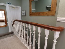 A staircase with a wooden railing in a hallway at 11 Rutland Street in Filey