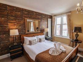 A bedroom with a bed and mirror at 11 Rutland Street Filey