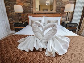 A bedroom with a towel sculpture on the bed at 11 Rutland Street in Filey