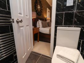 A bathroom with a toilet and a view of a bedroom at 11 Rutland Street in Filey