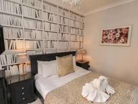 A bedroom with a bed and bookshelf wall at 11 Rutland Street, Filey