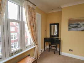 A bedroom with a desk and chair in front of a window at 11 Rutland Street in Filey