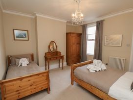 A bedroom with two beds and a dressing table at 11 Rutland Street, Filey