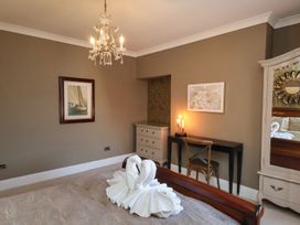 A bedroom with a bed and chandelier at 11 Rutland Street Filey