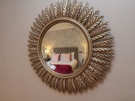 A mirror reflecting a bedroom setting at 11 Rutland Street in Filey