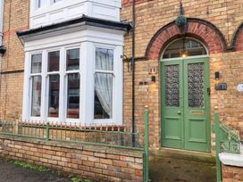 An entrance with a green front door and bay window at All Seasons in Filey