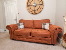 A sofa with a clock on the wall at All Seasons in Filey