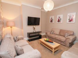 A living room with a television and coffee table at All Seasons in Filey