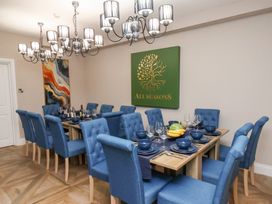 A dining room with a large table and blue chairs at All Seasons in Filey