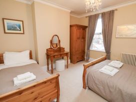 A bedroom with two beds and a wardrobe at All Seasons in Filey