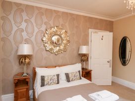 A bedroom with a bed and mirrors at All Seasons in Filey