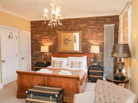 A bedroom with a bed and nightstands at All Seasons in Filey