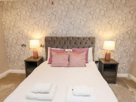 A bedroom with a bed and nightstands at All Seasons in Filey