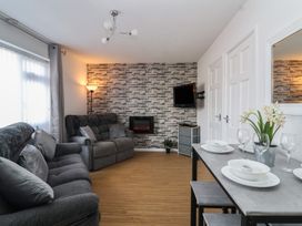 A living room with a sofa, television, and dining table at Flat 8 Burnham-on-Sea