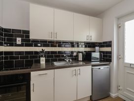A kitchen with cabinets, sink, microwave, kettle at Flat 8 in Burnham-on-Sea