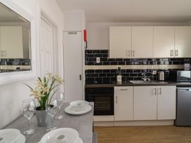 A kitchen with appliances and dining setup at Flat 8 Burnham-on-Sea