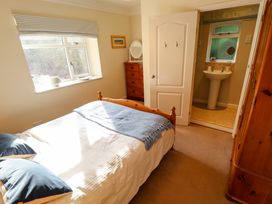 A bedroom with a bed and an en suite bathroom at Natterjacks in Syderstone