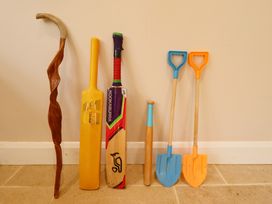 A selection of sports and garden tools including two cricket bats a wooden walking stick a small wooden club and two plastic garden spades at Natterjacks in Syderstone