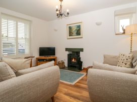 A living room with a television and fireplace at Capella Cottage in Keswick