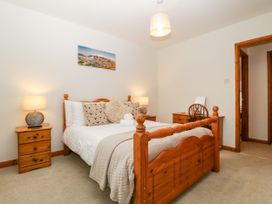 A bedroom with a bed and bedside table at Capella Cottage in Keswick