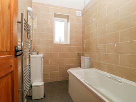 A bathroom with a tub, toilet, and sink at Capella Cottage in Keswick