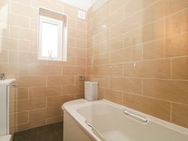 A bathroom with a bathtub, toilet, and sink at Capella Cottage in Keswick