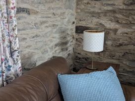 A sofa and lamp near a stone wall at La Bastille Maenclochog