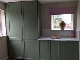 A kitchen with green cabinets and a window at La Bastille in Maenclochog