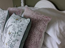 A bed with decorative pillows at La Bastille in Maenclochog