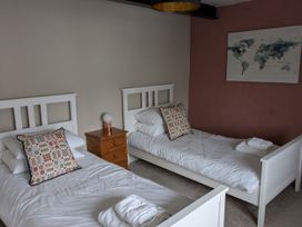 A bedroom with two single beds and a bedside table at La Bastille in Maenclochog