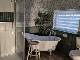 A bathroom featuring a bathtub, shower, toilet, and a plant at La Bastille Maenclochog
