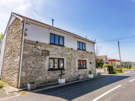 A house with stone exterior and windows on the street at La Bastille in Maenclochog