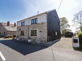 A house with stone and metal facade on a street at La Bastille in Maenclochog