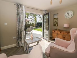 A living room with a patio door leading to a garden at La Bastille in Maenclochog