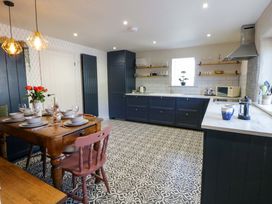 A kitchen with a dining table and appliances at La Bastille in Maenclochog