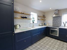 A kitchen with blue cabinets and appliances at La Bastille in Maenclochog