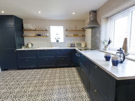 A kitchen with cabinets and appliances at La Bastille in Maenclochog