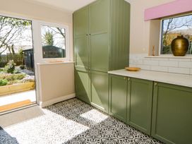 A kitchen with green cabinets and a window at La Bastille in Maenclochog