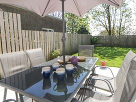 A garden dining area with table and chairs at La Bastille in Maenclochog