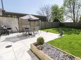 A garden with a table and chairs under an umbrella at La Bastille in Maenclochog